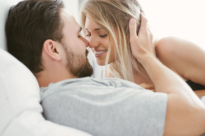 Young couple romancing on bed at home