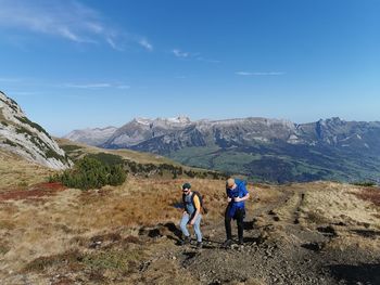 Friends on mountain against sky