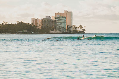 Scenic view of sea against buildings in city