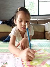 Girl drawing on book at table