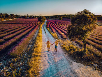 High angle view of couple walking on field against sky