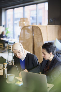 Businesswomen using digital tablet in cafe