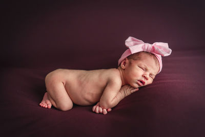 A newborn baby girl with a headband sleeping peacefully. newborn session concept