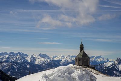 Church by snowcapped mountain against sky