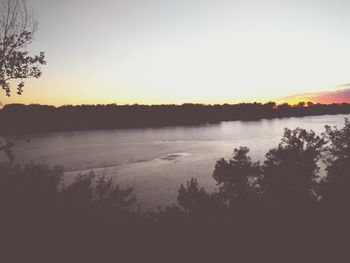 Scenic view of lake against clear sky during sunset