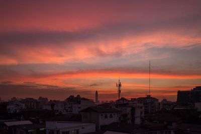 High angle view of silhouette buildings against orange sky
