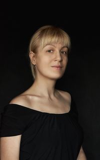 Portrait of young woman against black background