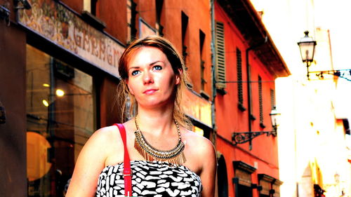 Beautiful woman standing against building in city