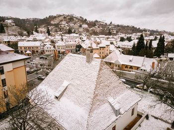Aerial view of houses in town against sky during winter
