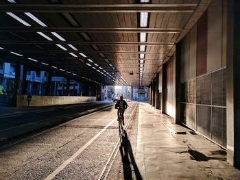 Contrasty backlighted men riding a bicycle in tunnel