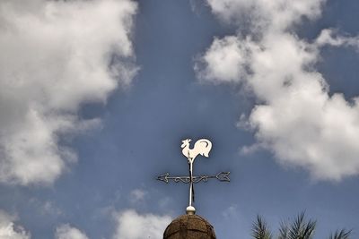 Low angle view of weather vane against sky