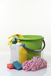 Close-up of bucket with cleaning equipment on white background