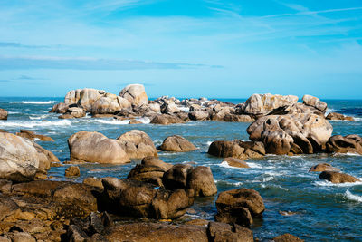 Rocks on beach against blue sky