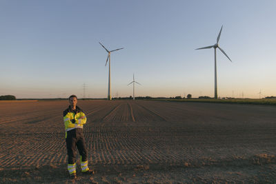 Engineer standing in a field at a wind farm