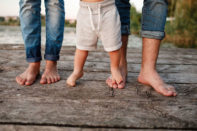 Bare feet of family. wooden bridge. mom, dad and baby walk bare feet on the wooden bridge. happy 