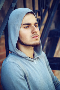 Young man looking away against railing