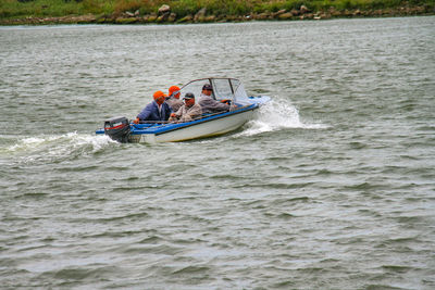 People in boat sailing on sea