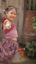 Portrait of smiling girl holding red umbrella