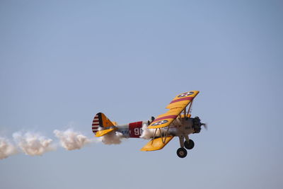 Low angle view of airplane flying against clear sky