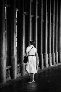 Rear view of woman walking in corridor of building