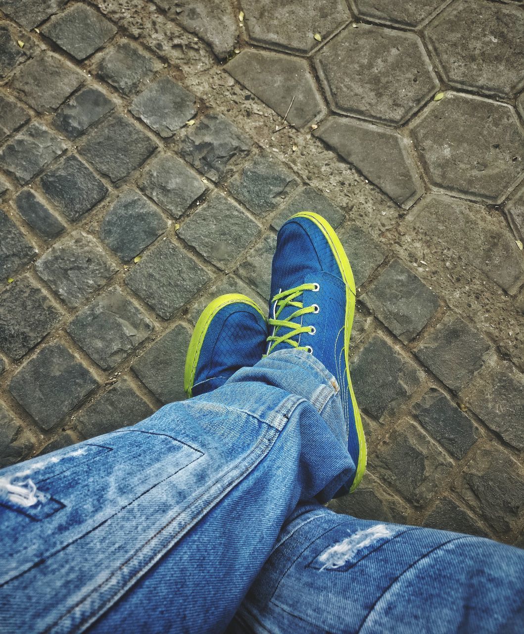 LOW SECTION OF MAN STANDING ON PAVING STONE STREET