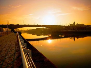 Bridge over river against sky during sunset