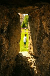 Rear view of a child though small stone window