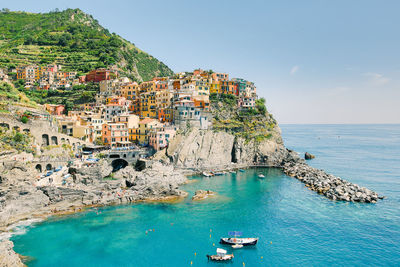 Aerial view of townscape by sea against sky