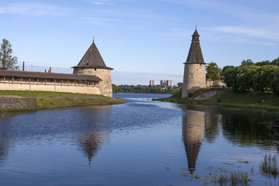 Built structure by river against sky