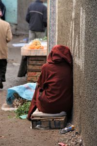 Rear view of man having food on street in city