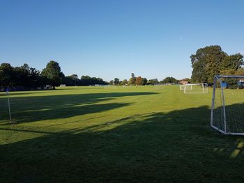 Scenic view of soccer field against clear sky