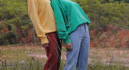 Midsection of couple standing on field