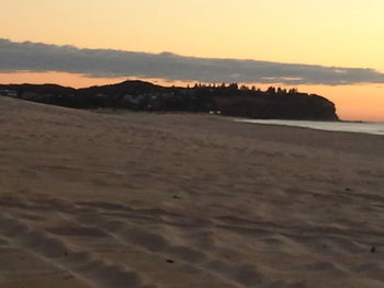 Scenic view of beach against sky during sunset