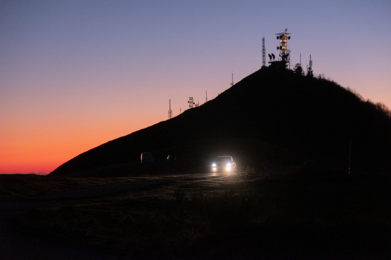 SILHOUETTE BUILDING ON MOUNTAIN AGAINST SKY AT SUNSET