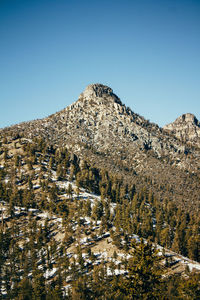 Low angle view of mountain range against clear blue sky