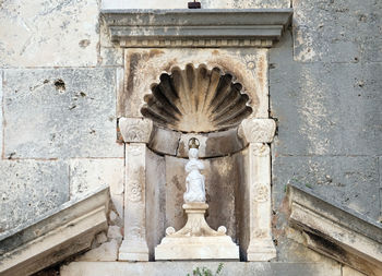 Statue of fountain against wall