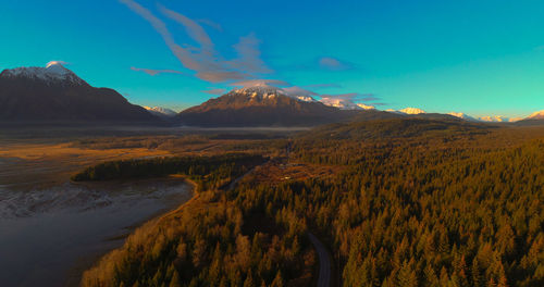 Scenic view of lake and mountains against blue sky