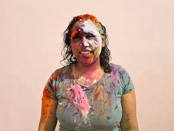 Portrait of happy indian woman celebrating holi with powder colours or gulal. indian festival holi.