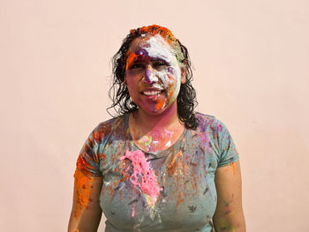 Portrait of happy indian woman celebrating holi with powder colours or gulal. indian festival holi.