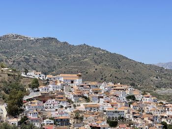 High angle view of the white townscape of cútar in southern andalusia against clear blue sky