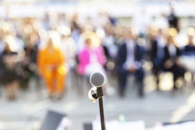 Publicity or media event, microphone in the focus against blurred people in the background