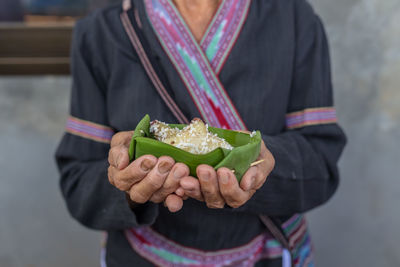 Midsection of woman holding ice cream standing outdoors