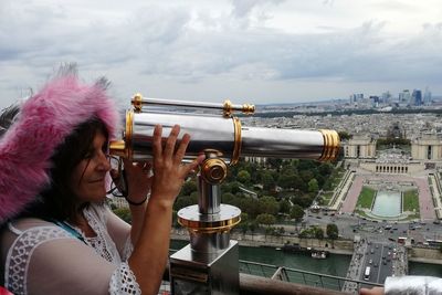 Woman looking through coin operated binoculars