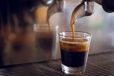 Close-up of glass at espresso machine