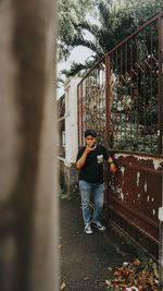 Man looking away while standing against plants