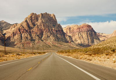 Road by mountain against sky