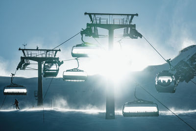 People skiing underneath ski lift in stormy conditions, kitzsteinhorn ski resort, austria