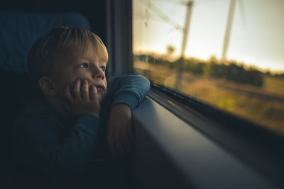 Portrait of smiling girl looking through window