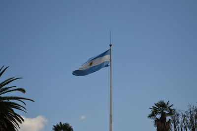 Low angle view of flag against clear blue sky