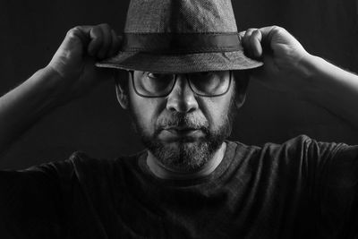 Black and white portrait of a man wearing a hat and glasses. isolated on black background.